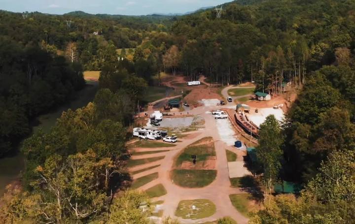 Aerial photo of the resort: gravel loops and clearings cut into the trees, with buildings near the entrance