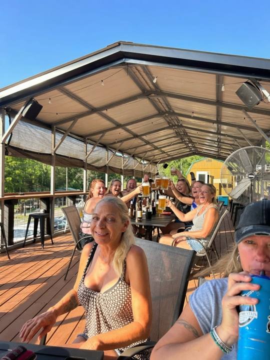 Guests smiling at tables on the covered deck
